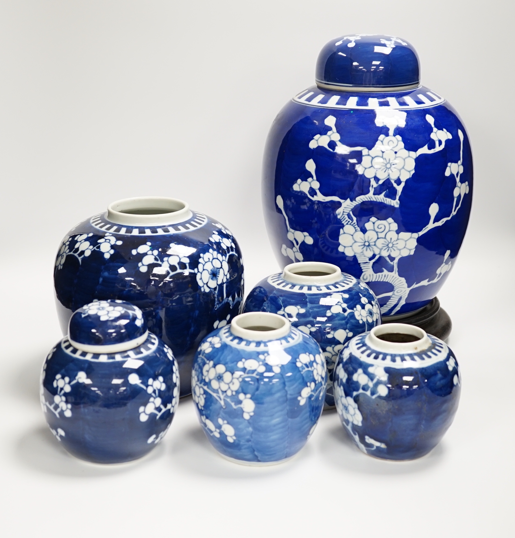 Six Chinese blue and white prunus jars two with covers, tallest 33cm including wooden vase stand